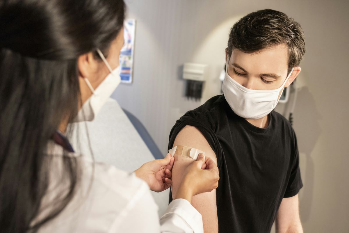 Medical assistant bandaging a patient