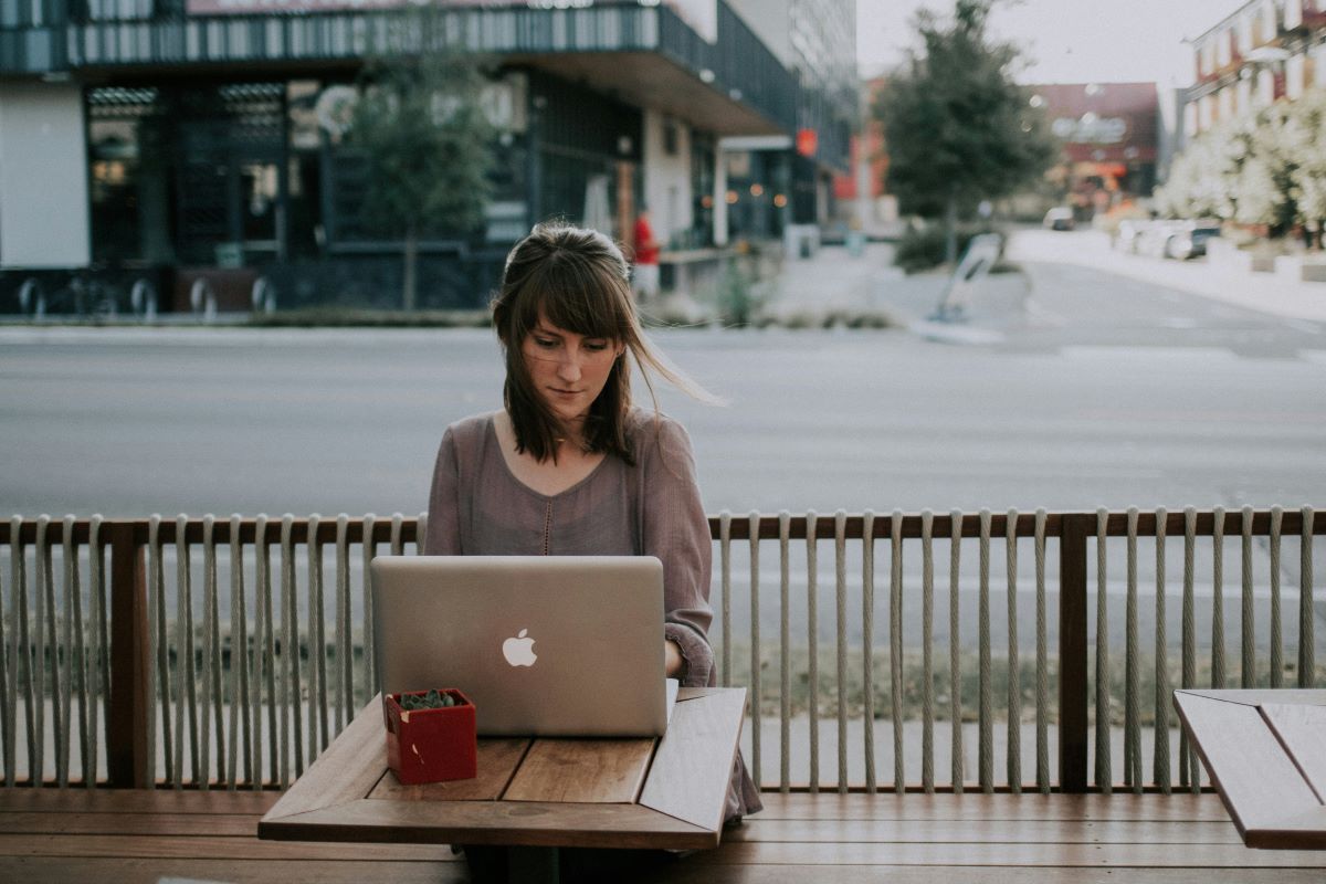 Working on a laptop outdoors in a cafe